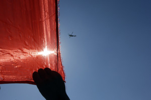 A police helicopter flies past a hand clasping a giant Chinese national during a protest outside the Japanese embassy in Beijing, China, Saturday, Sept. 15, 2012. Tensions between the two countries flared anew after the Japanese government bought the disputed islands from their private Japanese owners this week. The uninhabited islands, Senkaku in Japan and Diaoyu in China, claimed by both countries as well as Taiwan, have become a rallying point for nationalists on both sides.(AP Photo/Ng Han Guan)