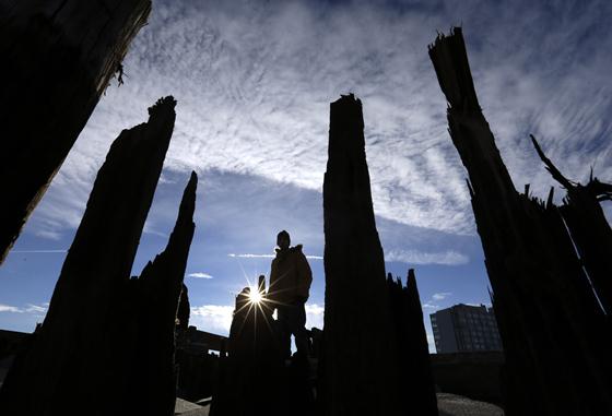 A man walks past shards of wood that were part of a boardwalk that was destroyed by superstorm Sandy, in Atlantic City, N.J. on Thursday, Nov. 1, 2012. (AP Photo/Patrick Semansky)